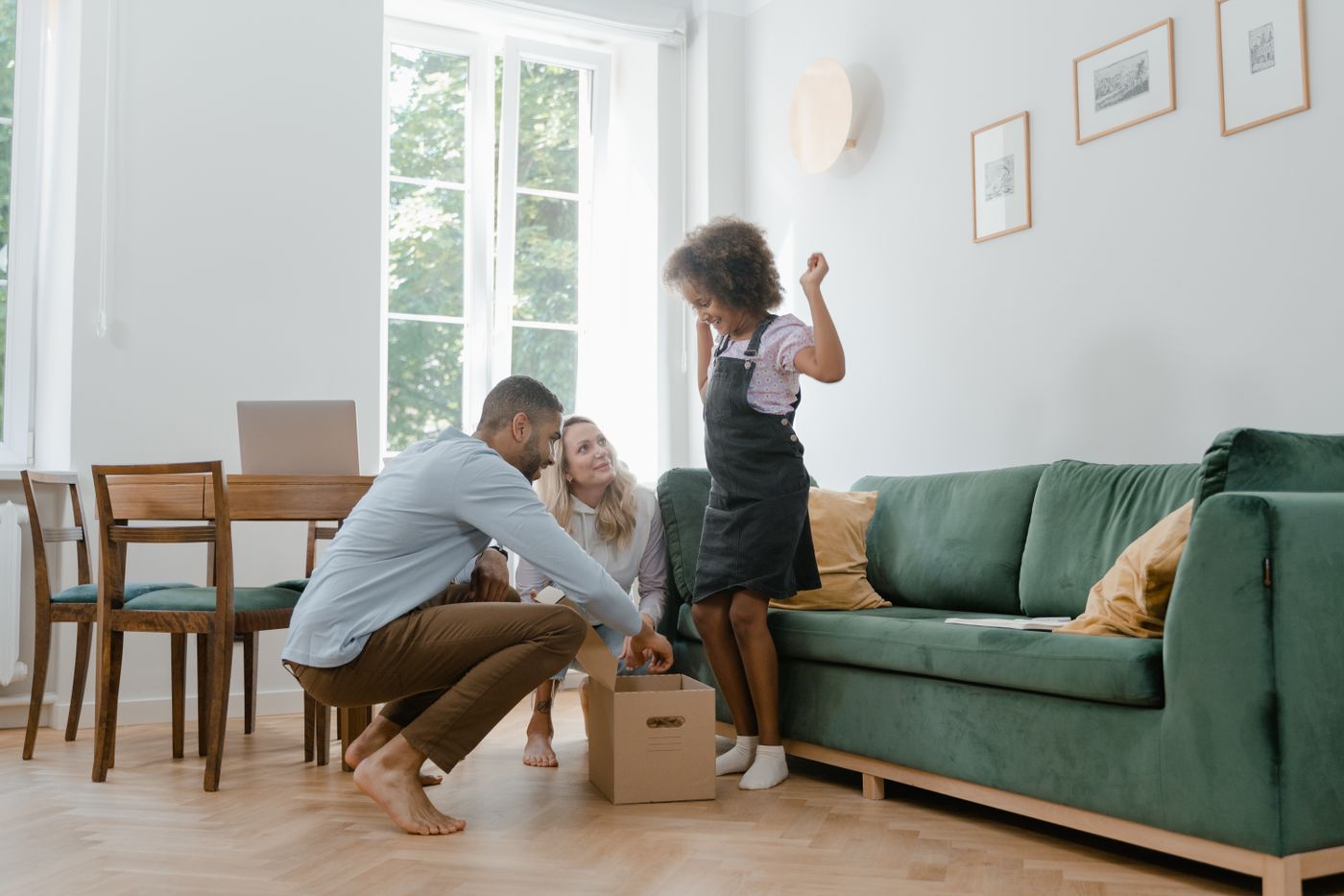 Family celebrating in their new living room beside a moving box