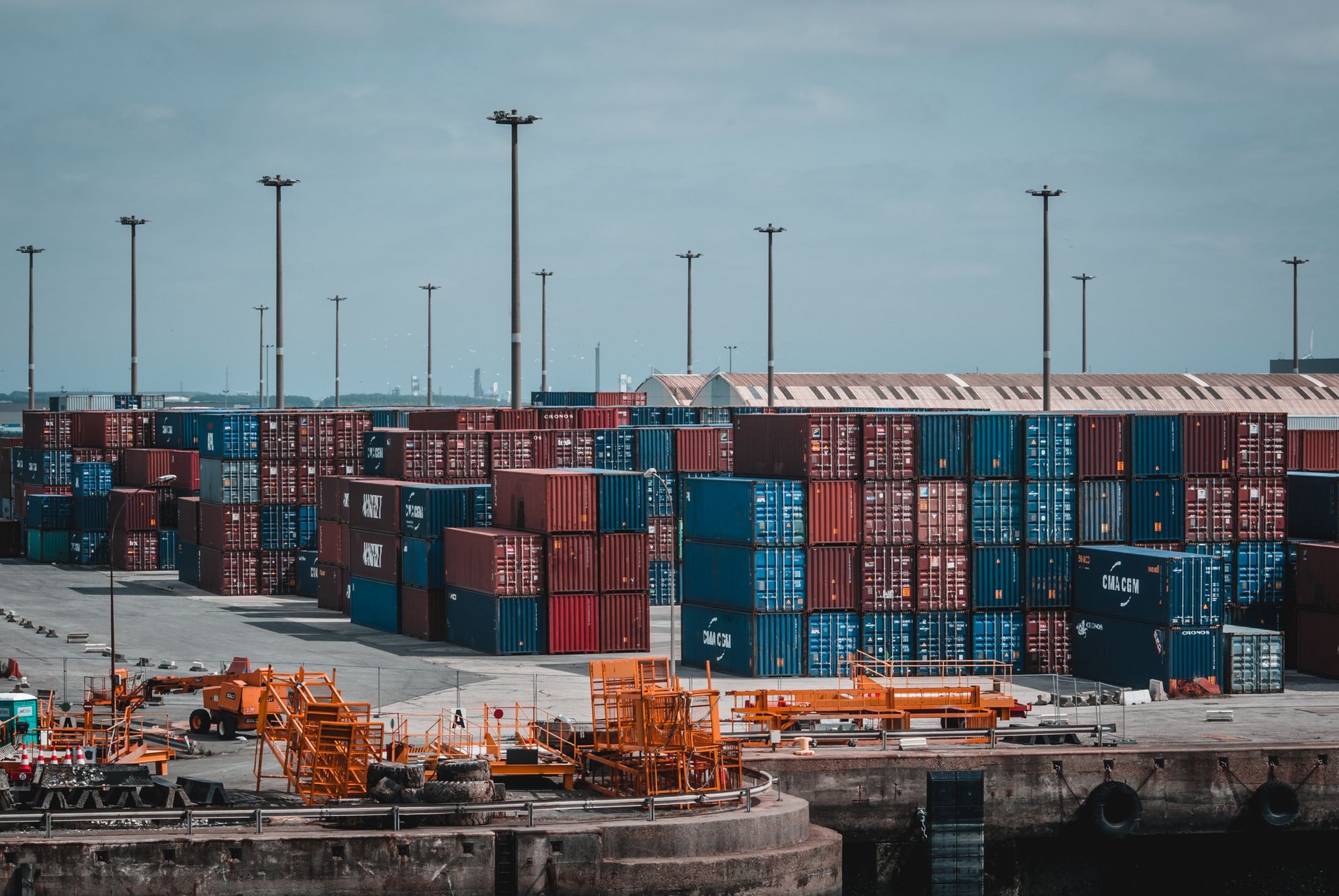 Stacked intermodal shipping containers at a busy industrial port